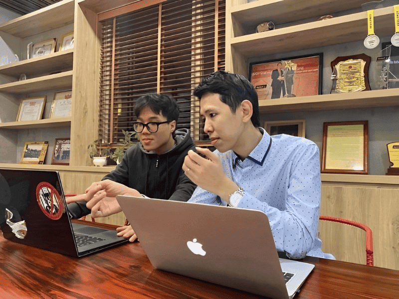 hình 2 kỹ sư IT đang bàn luận các vấn đề trong project và laptop